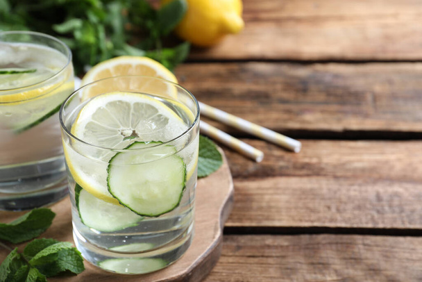 Refreshing water with cucumber, lemon and mint on wooden table, closeup. Space for text - Φωτογραφία, εικόνα