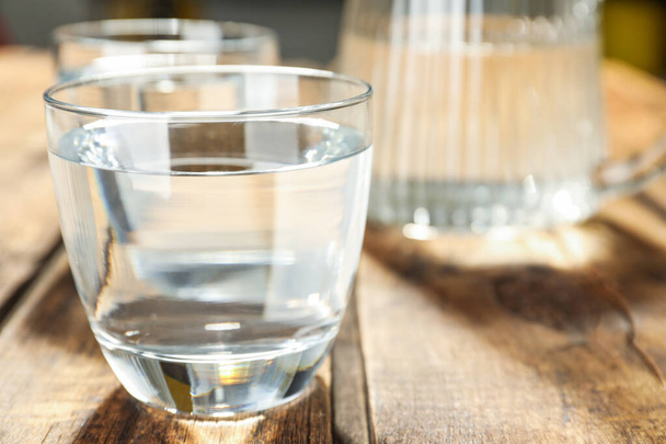 Glass of water on wooden table, closeup. Refreshing drink - Foto, immagini