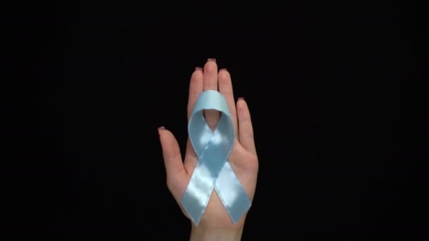 Παγκόσμια ημέρα διαβήτη. Μπλε κορδέλα συμβολική απομονωμένη με υποστήριξη χεριών. - Πλάνα, βίντεο