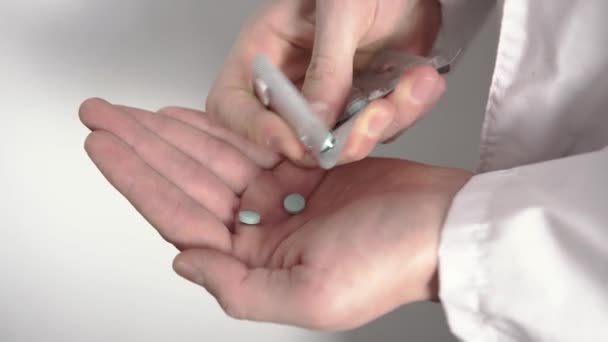 Gros plan d'une main de médecin qui reçoit toutes les pilules de la plaquette thermoformée et les prend - Séquence, vidéo