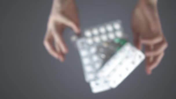 Manos lanza blisters con pastillas en la superficie transparente en cámara lenta - Imágenes, Vídeo