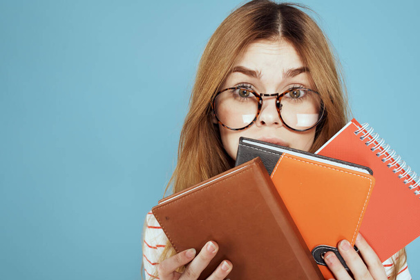 energetic female student with notepads and glasses model blue background - Φωτογραφία, εικόνα