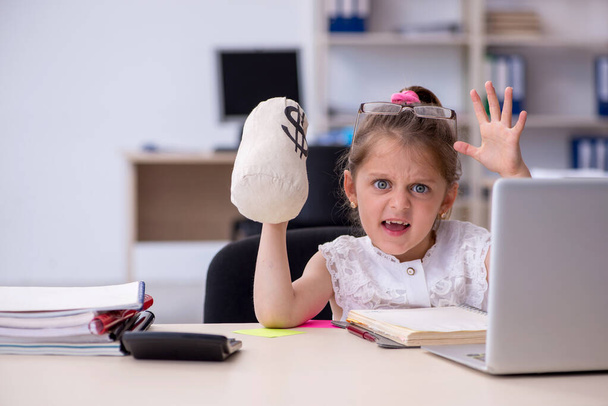 Graciosa niña pequeña recibiendo salario en la oficina - Foto, Imagen