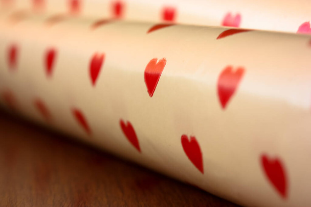 Gift white paper with little red hearts, holiday background on Valentine's Day or Valentine's Day. - 写真・画像