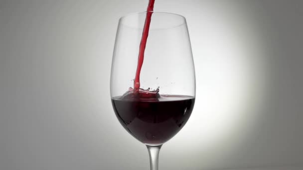 Αργή κίνηση βολή του κόκκινου κρασιού που χύνεται στο γυαλί - Πλάνα, βίντεο