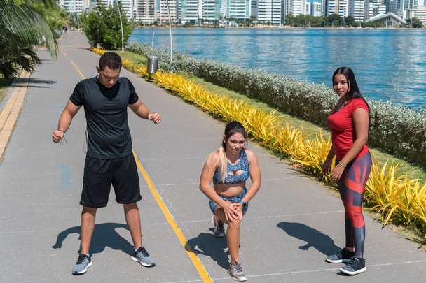 Group of young athletes stretching before train in the park. Fitness concept - Photo, Image