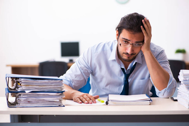 Junge männliche Angestellte unzufrieden mit exzessiver Arbeit im Büro - Foto, Bild
