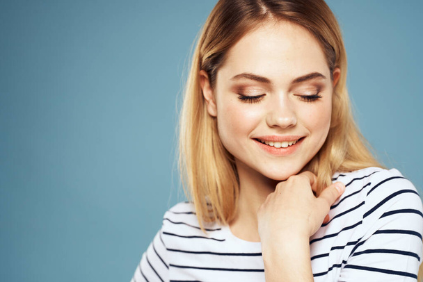 Blonde girl in striped t-shirt lifestyle blue background fun - Foto, Imagem