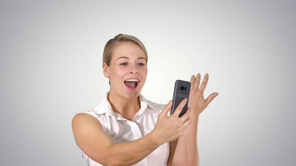 vrouw draagt roze maken video gesprek op de smartphone lopen - Foto, afbeelding
