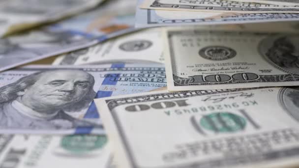 Rengeteg amerikai bankjegy van az asztalon. Száz amerikai dollár bankjegyei - Felvétel, videó