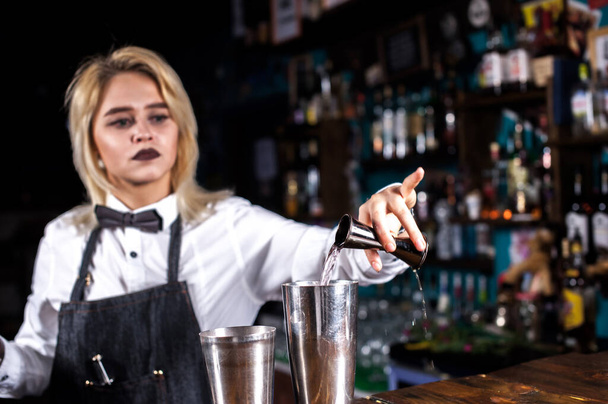 Ritratto di ragazza barista fa uno spettacolo creando un cocktail sul bar - Foto, immagini