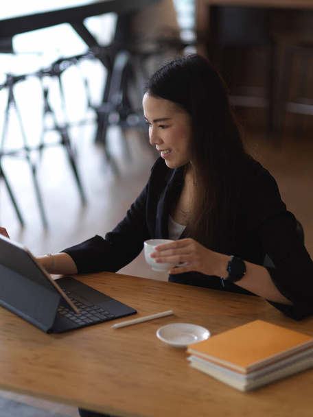 Portret bizneswoman zrobić przerwę na kawę podczas pracy z tabletem w biurze - Zdjęcie, obraz