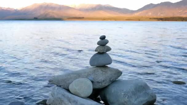 Piedra zen con el fondo del monte John en el lago Tekapo, Isla Sur, Nueva Zelanda. - Metraje, vídeo