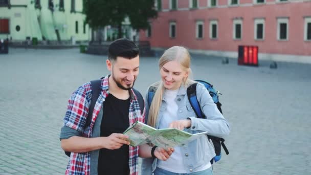 Tourists with map looking for new historical place in city center - Footage, Video