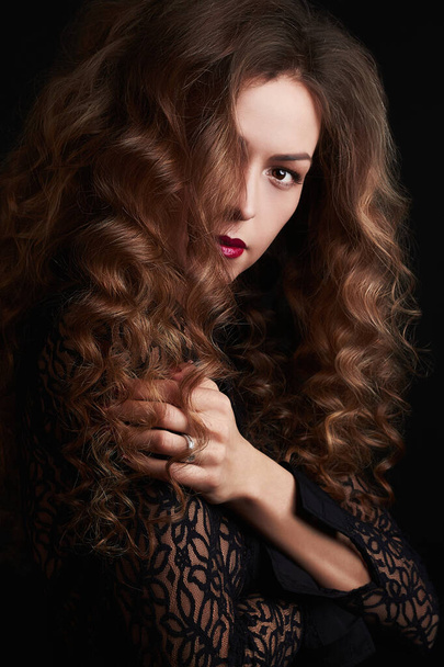 Kıvırcık, sağlıklı saçlı güzel bir genç kadının moda portresi. Gizemli kız. saç stili - Fotoğraf, Görsel