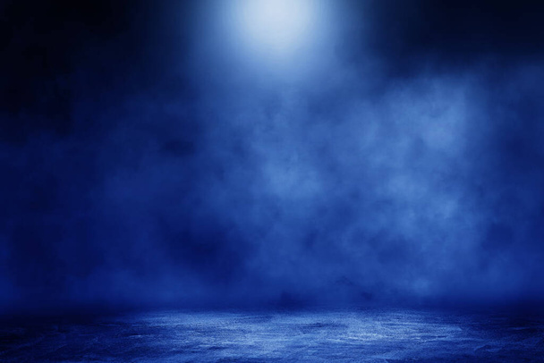Пустое пространство студии темной комнаты бетонный пол гранж текстура фон с синим светом эффект и дым на заднем плане. - Фото, изображение
