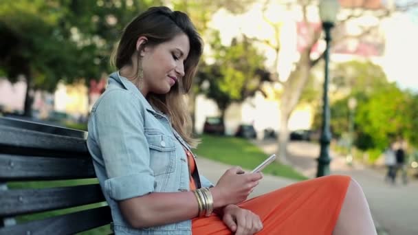 Woman using smartphone in city park - Video, Çekim