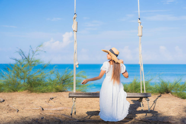 Portrait beautiful young asian woman relax smile on swing around beach sea ocean for nature travel in vacation - Photo, Image