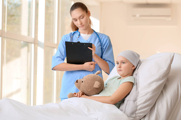 Enfermera y niña en tratamiento de quimioterapia en la clínica - Foto, Imagen