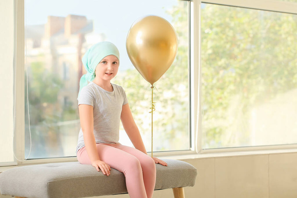 Klinikte altın balonlu küçük bir kız. Çocukluk kanseri farkındalığı - Fotoğraf, Görsel