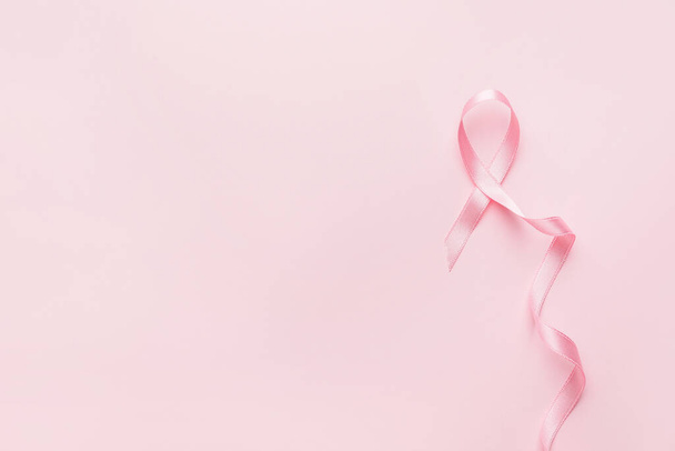 Pink ribbon on color background. Breast cancer awareness concept - Foto, immagini