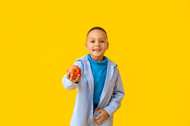 Cute African-American chłopiec z jabłkiem na tle koloru - Zdjęcie, obraz