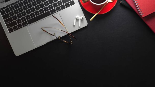 Laptop, kahve fincanı ve ofis malzemeleriyle modern çalışma alanının en üst görüntüsü fotokopi alanı ile siyah tablet üzerinde  - Fotoğraf, Görsel