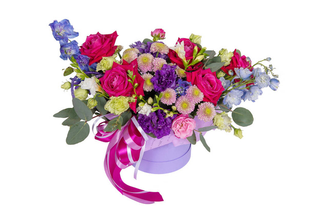 Boîte en carton contenant un arrangement floral avec des roses, des chrysanthèmes et des feuilles isolées sur fond blanc - Photo, image