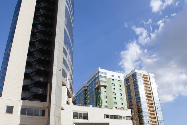 Modern hoogbouw met woonkamers tegen een blauwe lucht. - Foto, afbeelding