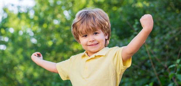 Smiling child boy. Cheerful cheerful kid. Happy children kid boy with hands up. Child outdoors in nature. Happy child - 写真・画像