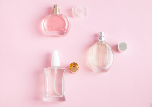 Beaux parfums pour femmes, sur fond de rose isolé. - Photo, image