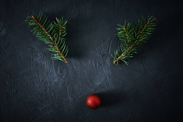 Cervo de Natal feito de ramos de abeto e bugiganga festiva em um fundo escuro. Conceito de Natal - Foto, Imagem