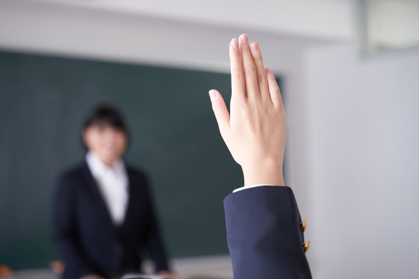 Μια Γιαπωνέζα μαθήτρια λυκείου σηκώνει το χέρι της στην τάξη. - Φωτογραφία, εικόνα