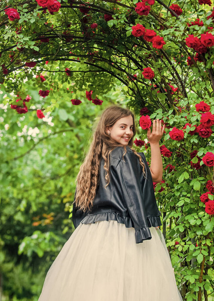 Trendy girl fancy dress and leather jacket in roses garden, stylish princess concept - Фото, изображение
