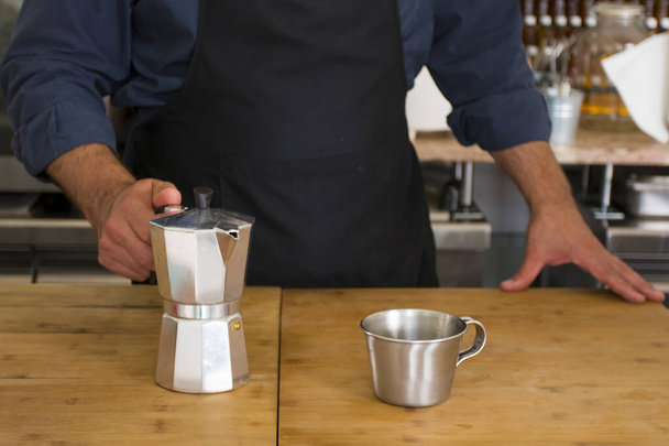 Mężczyzna Barista przygotowuje świeże espresso w ekspresie do kawy dla klienta w fantazyjnej kawiarni. Właściciel kawiarni obsługujący klienta w kawiarni. - Zdjęcie, obraz