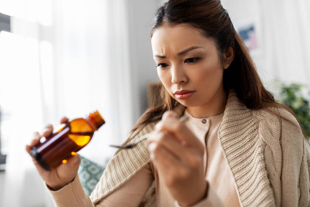 sick asian woman taking medicine at home - Foto, Bild