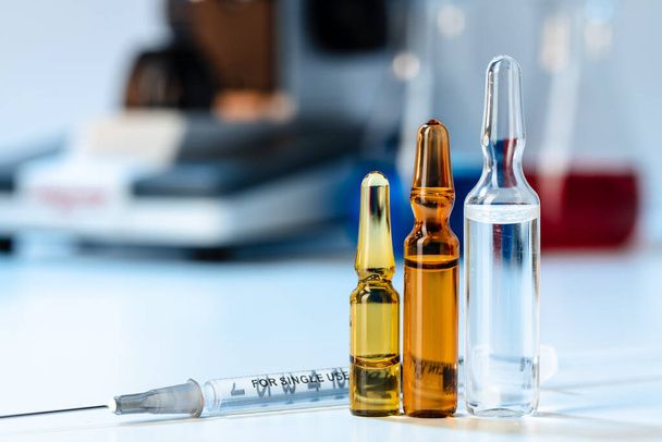 Vial of vaccine bottle with a syringe close up - Valokuva, kuva