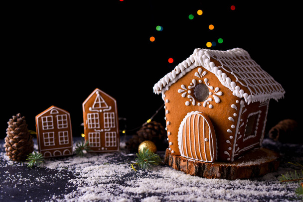 Pencerelerinden gelen ışığı, zencefilli kek şehrini, büyük yan ışıkları ve karı olan kış zencefilli kek evi. Yeni yıl içeriği. Noel kartı.. - Fotoğraf, Görsel