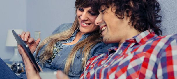 Paar verliefd uitziende elektronische tablet en lachen - Foto, afbeelding