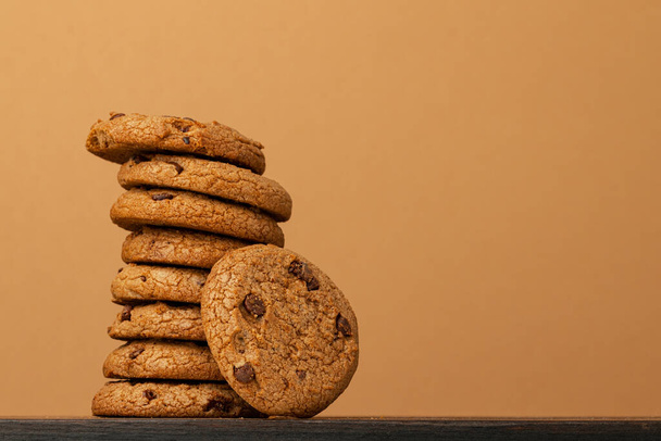 Stacked chocolate chip cookies against beige background - Photo, Image