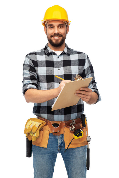 male worker or builder in helmet with clipboard - Fotó, kép