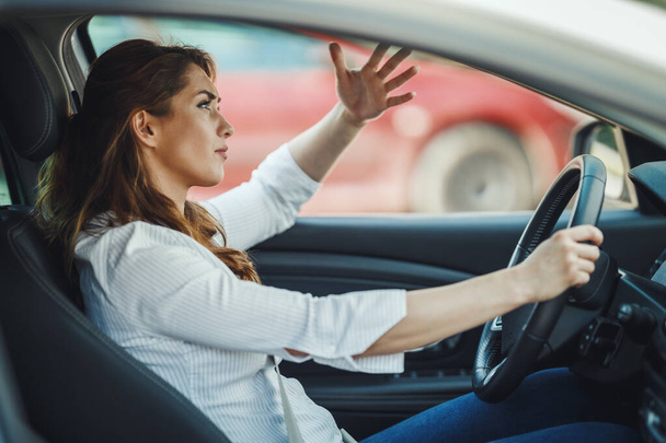 Fotografía de una mujer de negocios estresada conduciendo su coche en un atasco de tráfico durante su viaje matutino. - Foto, imagen