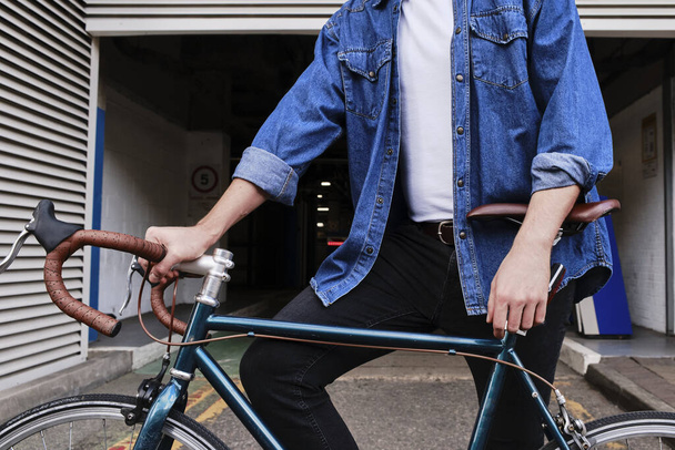 Closeup Of A Freelancer Professional Young Man Standing With His  Bike Outside. - Foto, imagen