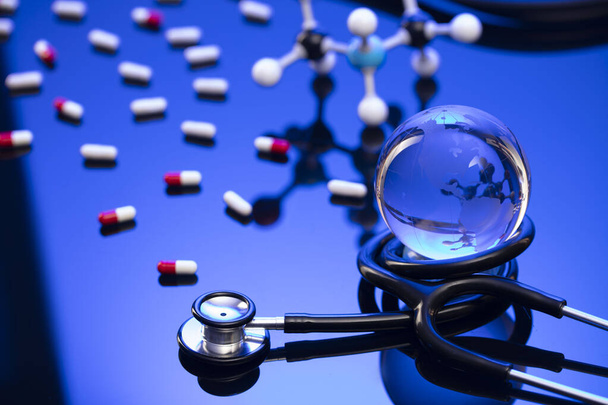 Concepto de salud. Estetoscopio y medicamentos. Mesa azul y fondo. - Foto, Imagen