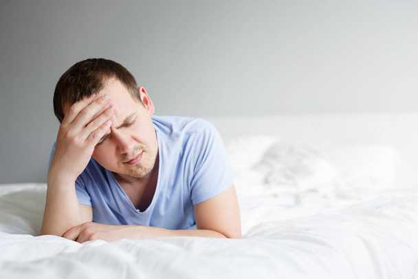 slapeloosheid, depressie en hoofdpijn - portret van vermoeide man die thuis op bed ligt - Foto, afbeelding