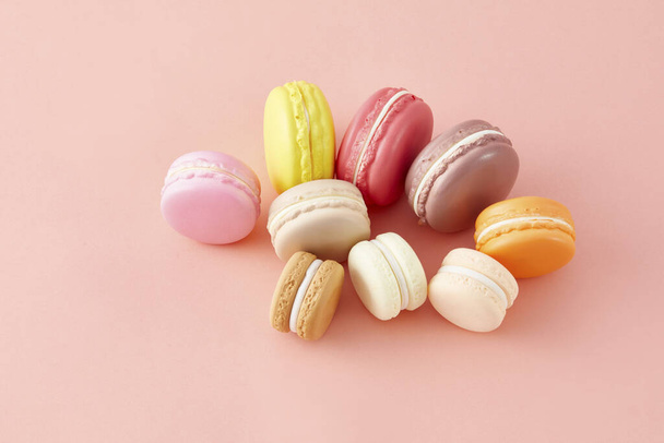 A closeup of various colorful macaroons isolated on a light pink background - Photo, Image