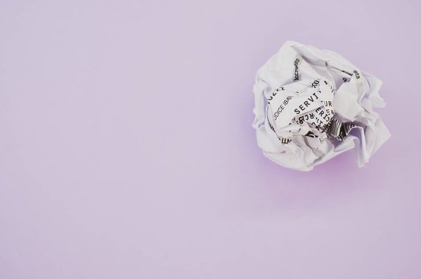 A high angle shot of a wrapped paper ball isolated on a violet background - Photo, Image