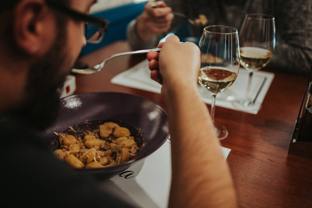 A high angle shot of a person eating a dish in the restaurant - Photo, image