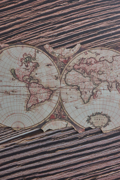 A top view on an old ancient map of the world placed on a wooden table - Foto, Imagen
