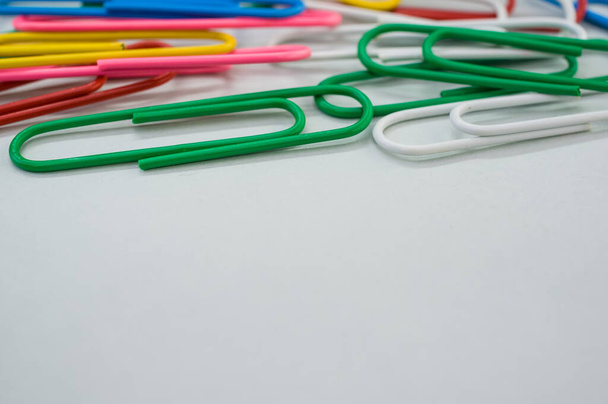 A closeup shot of colorful paper clips on a green background - Photo, image